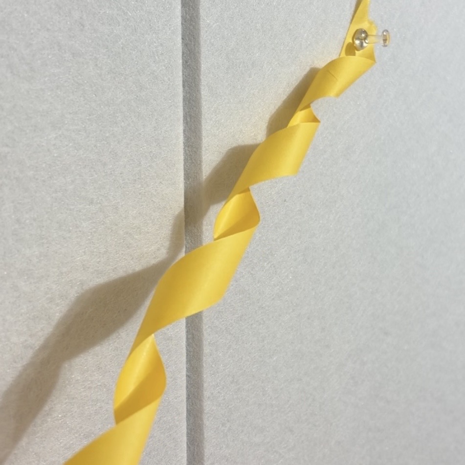 紙テープをくるくると形作りながら留める様子